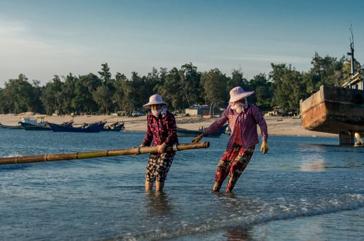 Men Pulling Bamboo on Water