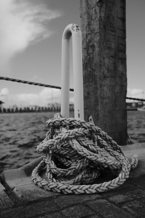 A black and white photo of a rope tied to a dock