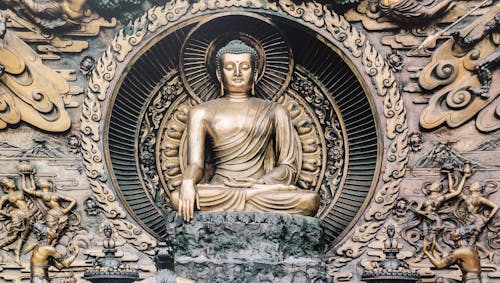 A buddha statue in a gold frame with a lotus flower