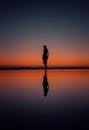 Woman Silhouette on Sea Shore at Sunset