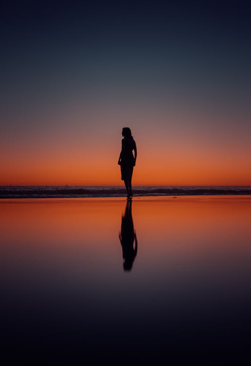 Woman Silhouette on Sea Shore at Sunset