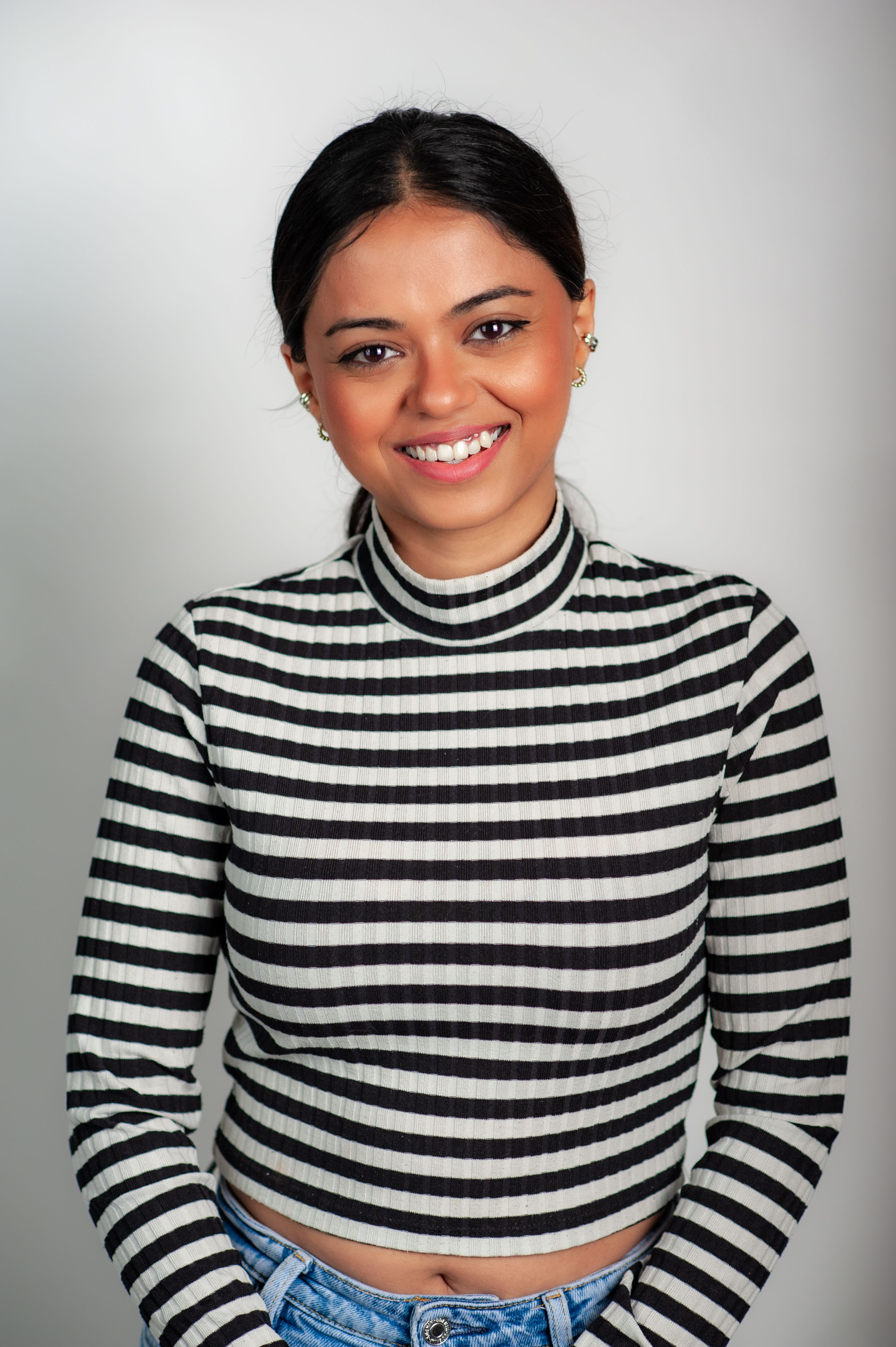 Smiling Woman in Striped Sweater on White Background · Free Stock Photo