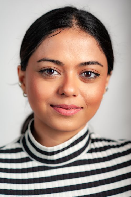 Free Close-up portrait of a woman with a confident expression, wearing a striped blouse on a white background. Stock Photo