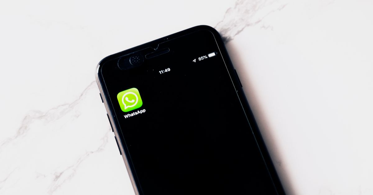 Hispanic woman on smartphone comparing auto insurance options in Texas, WhatsApp open on screen