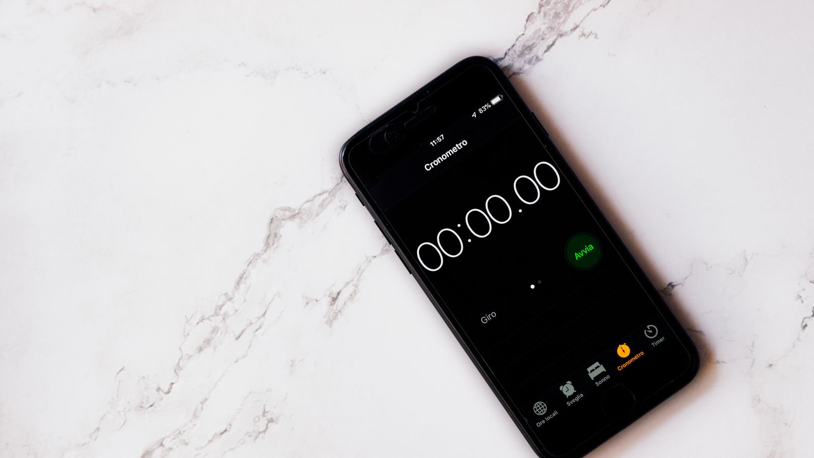 A smartphone displaying a stopwatch on a white marble surface