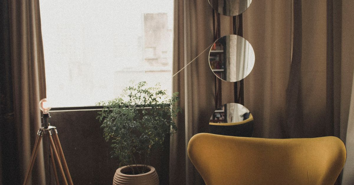 Rüyada Aynalarla Dolu Bir Oda Görmek - Rüya Tabiri ve Anlamı - Warm and stylish room featuring yellow chair, plants, and mirrors.