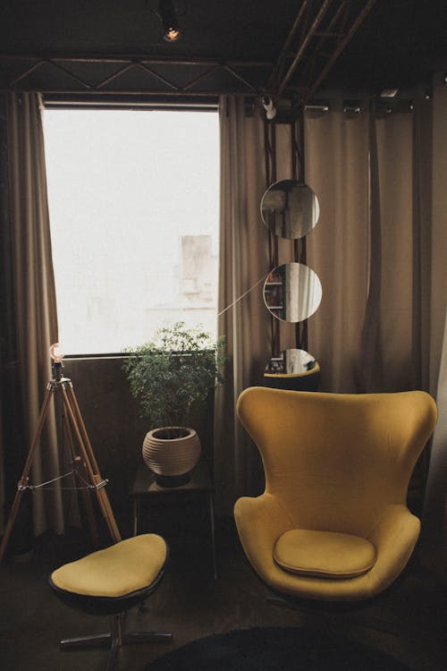 Yellow Chair Near Three Round Mirrors