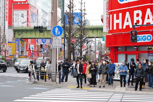 Bustling Tokyo intersection with pedestrians and vibrant storefronts.