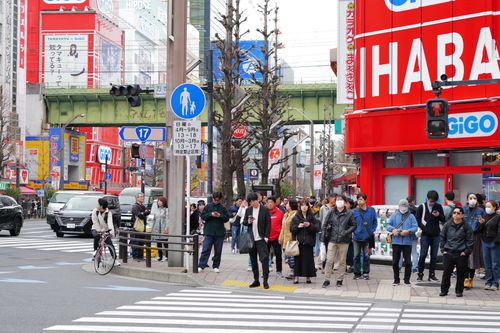 Free Bustling Tokyo intersection with pedestrians and vibrant storefronts. Stock Photo