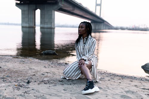 Vrouw Geknield Op Zand In De Buurt Van Rivier En Brug