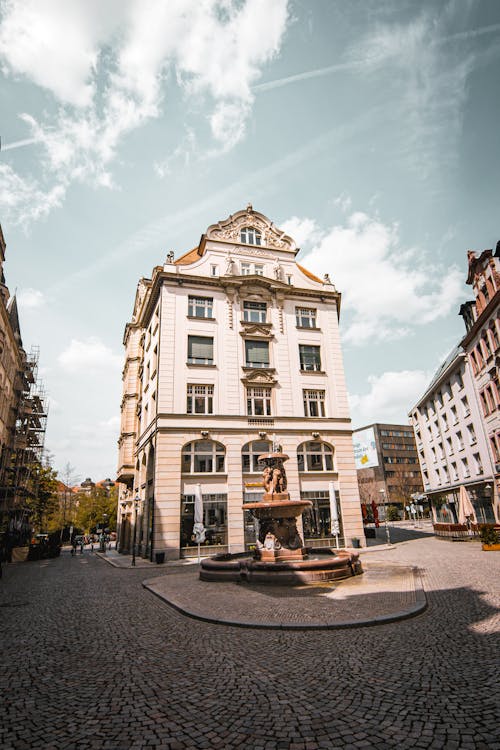 A building with a fountain in the middle of the street