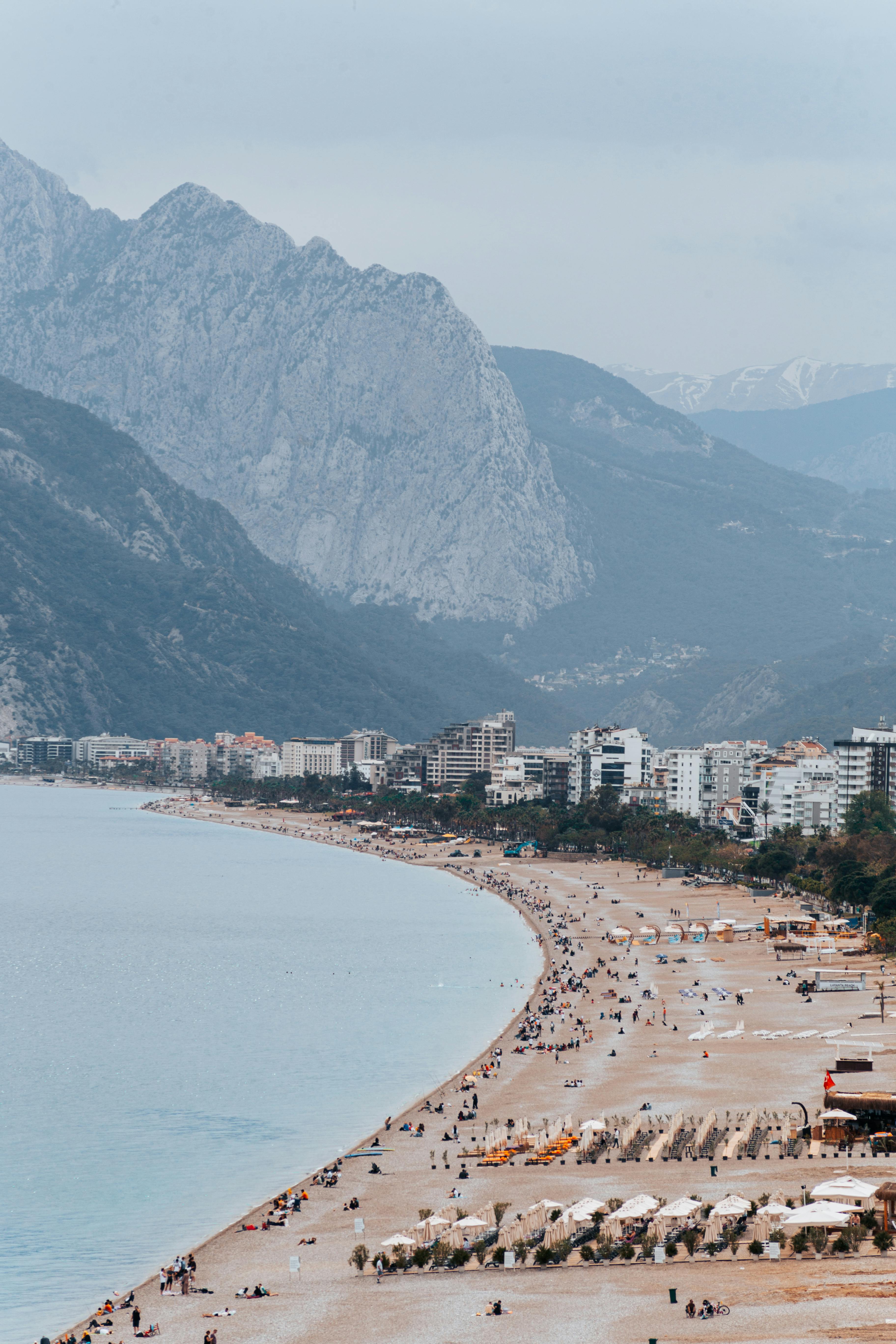 Discover the breathtaking Konyaaltı Beach with mountains and cityscape in Antalya, Türkiye.