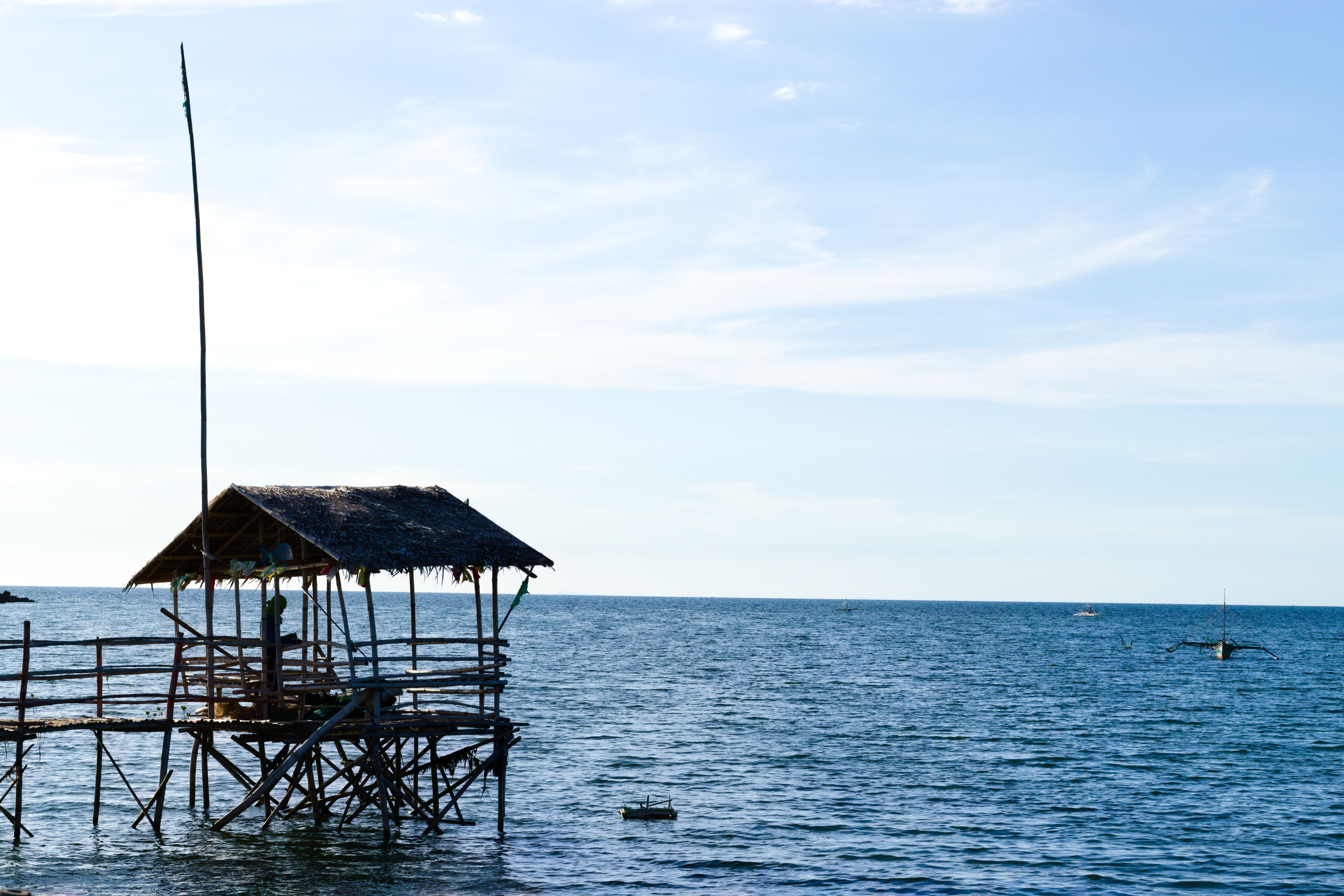 A rustic wooden hut on stilts over a peaceful ocean horizon, perfect for a serene summer escape. - Fotografer Sidoarjo