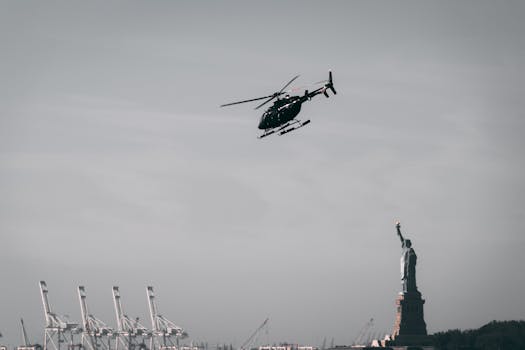 A helicopter in flight near the iconic Statue of Liberty in New York City.