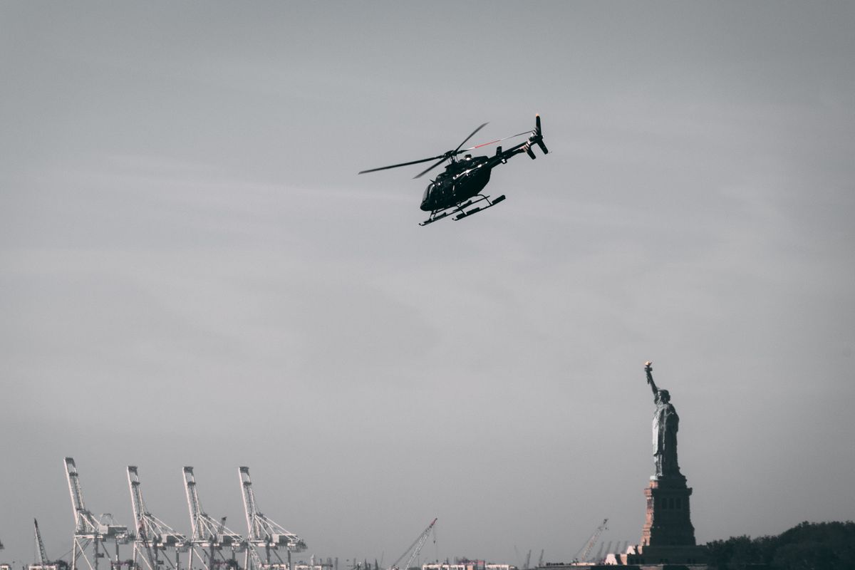 eVTOL air taxi helicopter flying near Statue of Liberty over New York harbor