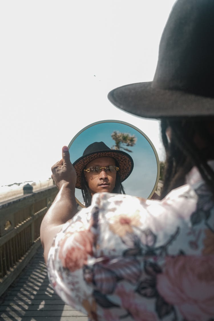 Man In Hat Looking In Mirror