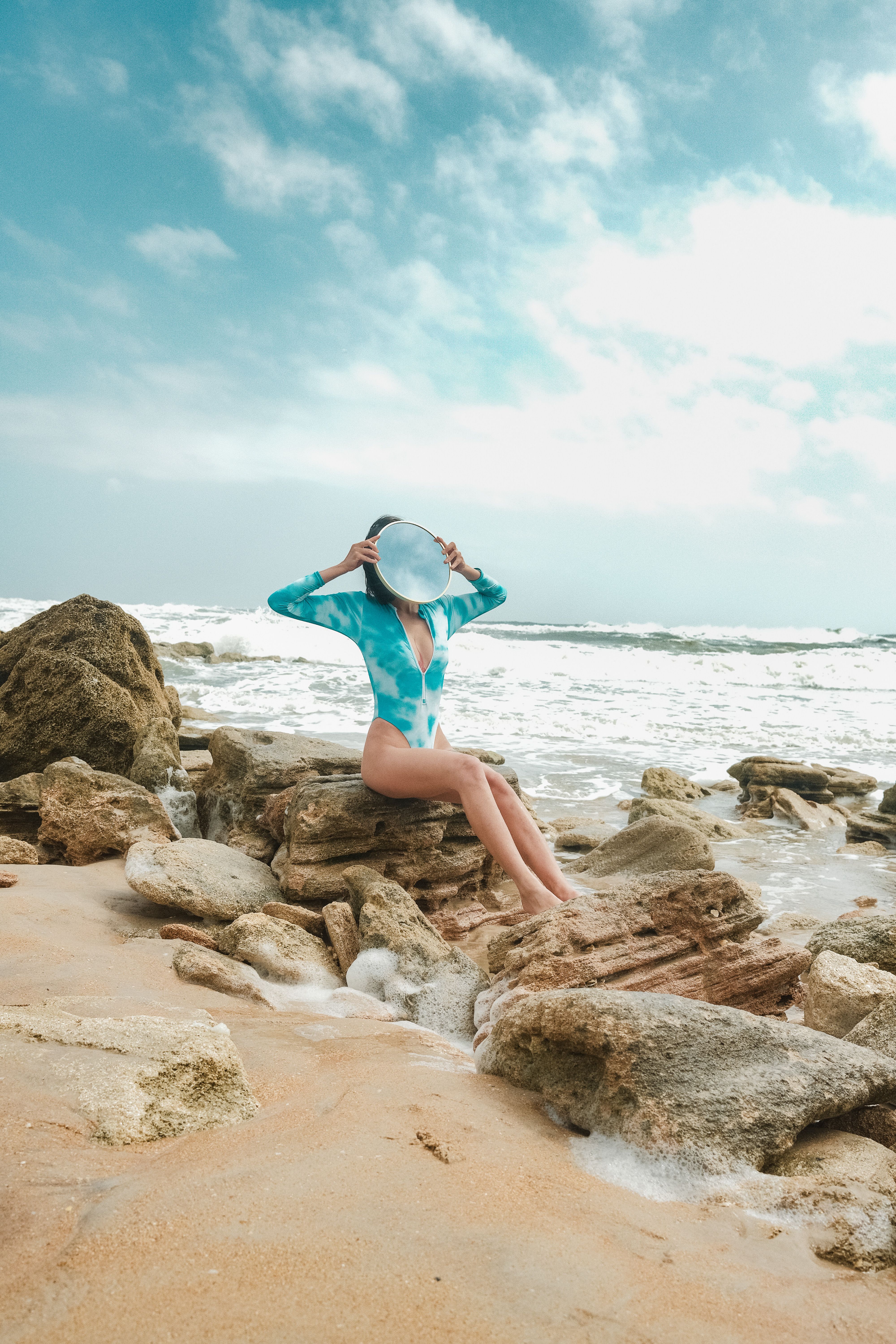 Woman Sits on Rock with Mirror on Face · Free Stock Photo