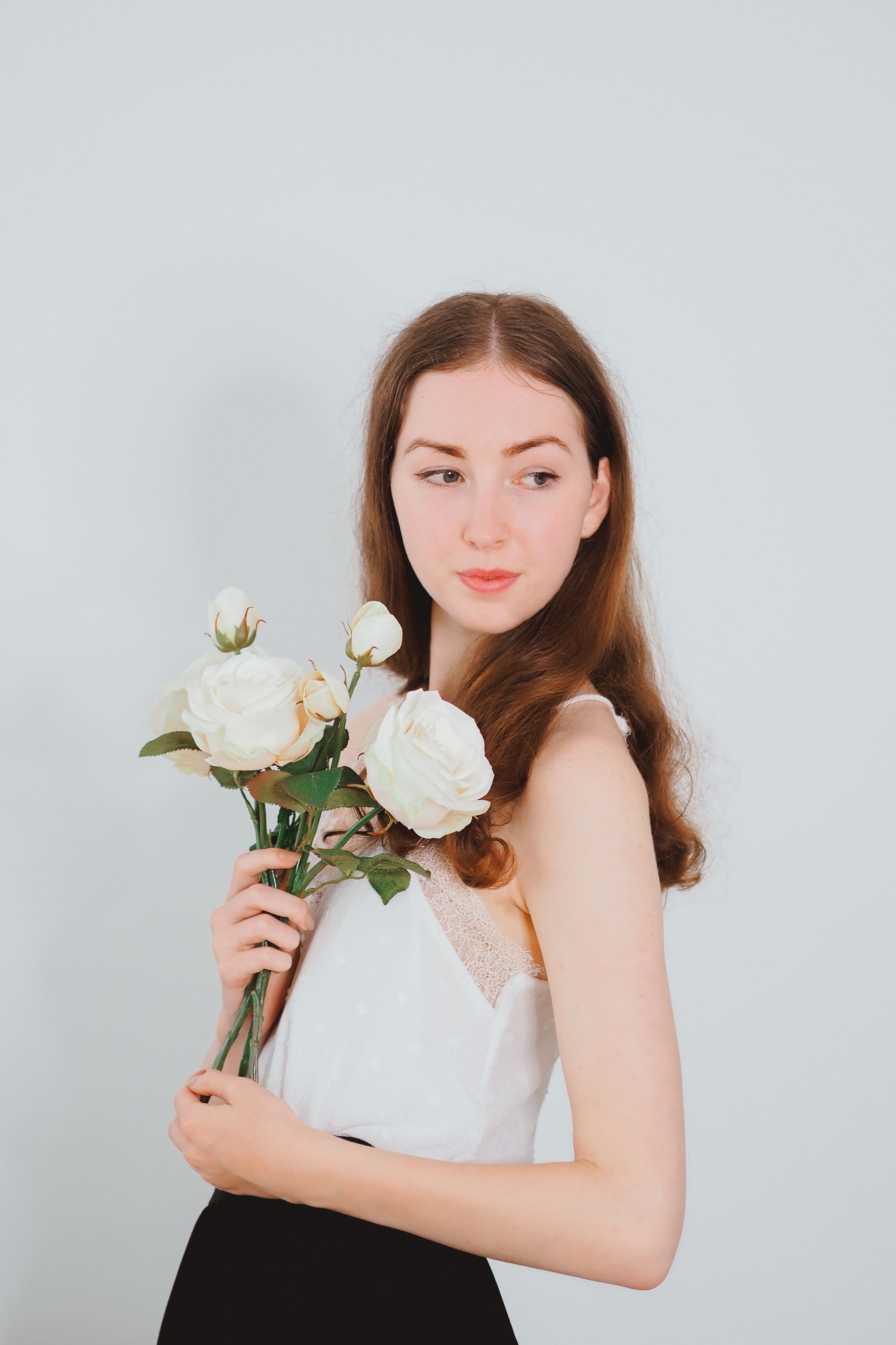 Portrait of Woman Standing and Holding Roses · Free Stock Photo