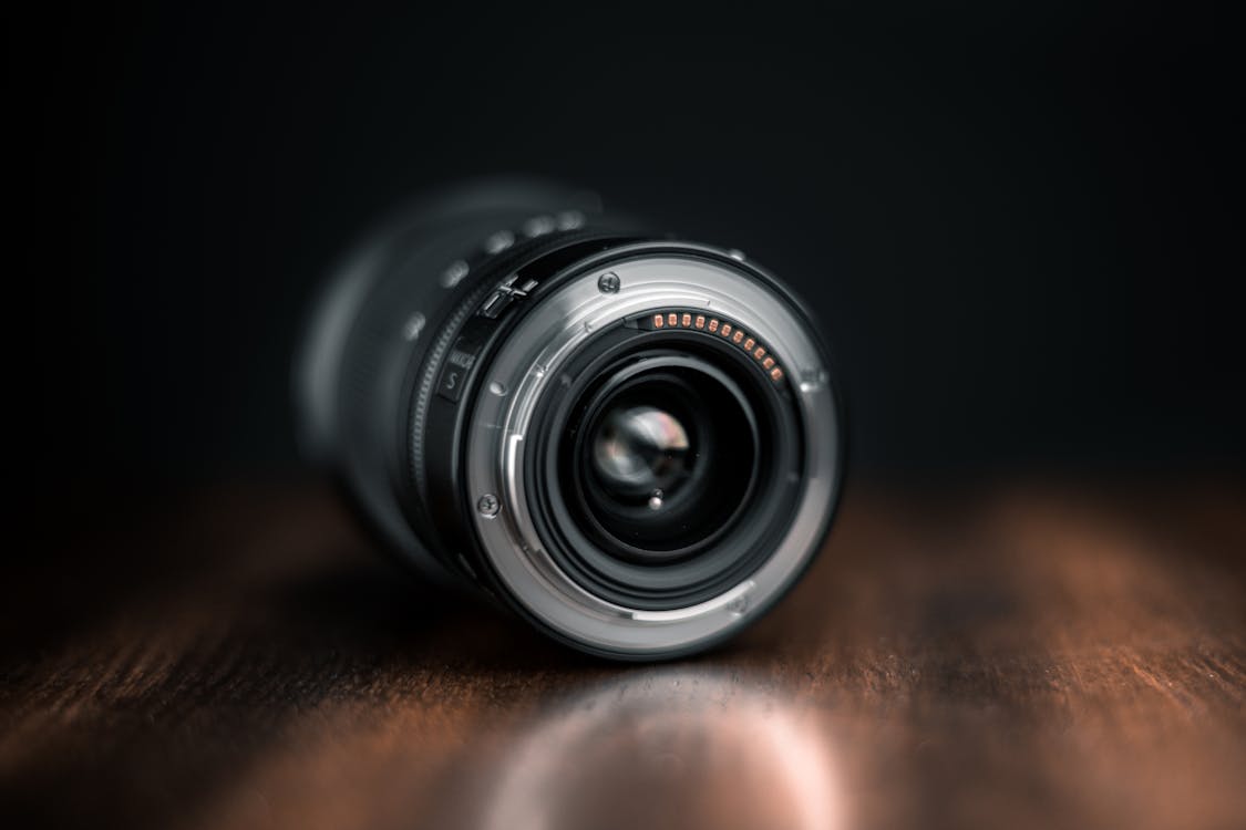 Selective Focus Photography of Camera Lens on Wooden Surface