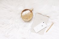 White Iphone, Gold-colored Pen, and Round Gold-colored Cup