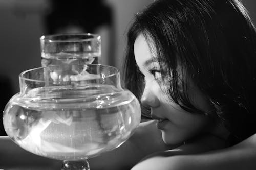 A woman is looking at a glass of water