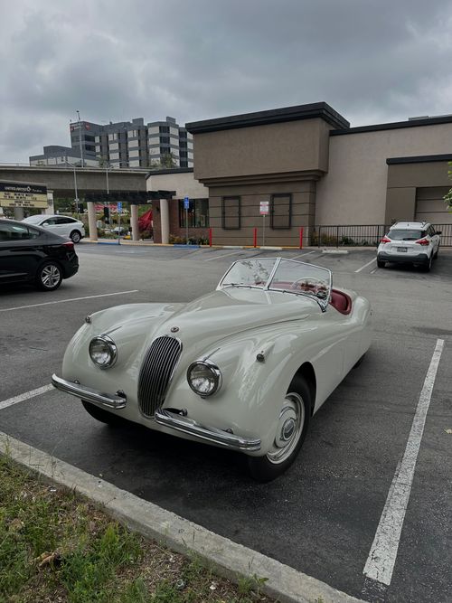 Free Classic Jaguar XK120 cabriolet parked in urban setting, showcasing vintage design and elegance. Stock Photo