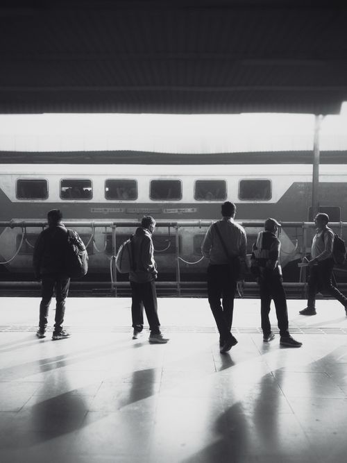 Free Black and white photo of commuters standing at Surat Railway Station, India. Stock Photo