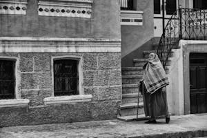 Grayscale Photography of Person Walking on Sidewalk