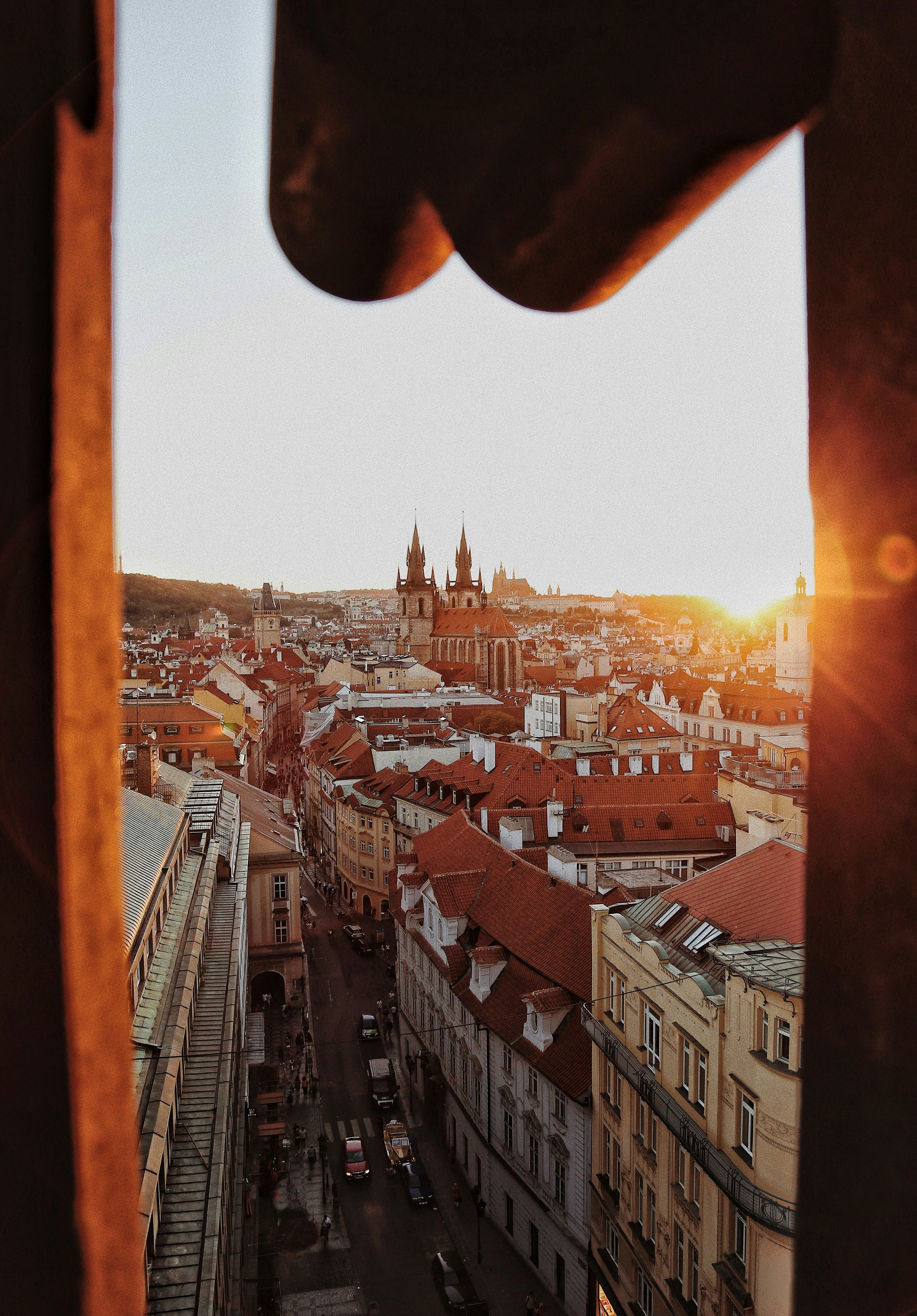 Scenic aerial view of Prague's historic architecture at sunrise with warm sunlight highlighting the cityscape.