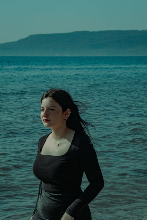 A woman standing in the water near the ocean