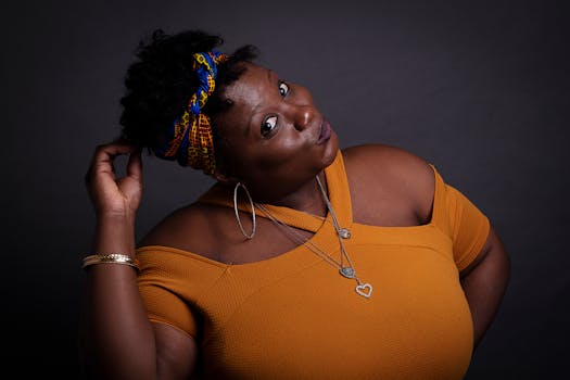 这幅迷人的工作室肖像描绘了一位时尚女性，她佩戴着大胆的配饰，头戴色彩缤纷的头巾