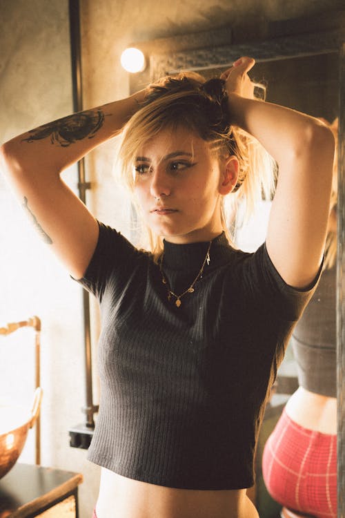 Woman Wearing Black T-shirt Holding Head With Both Hands