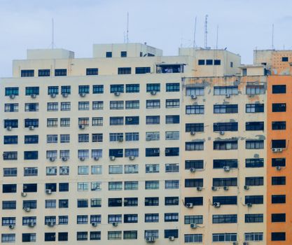 阴天里，一座现代化的高层公寓楼装有许多空调和天线