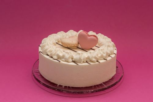 Free Delicious cake topped with heart-shaped macarons, perfect for romantic occasions. Stock Photo