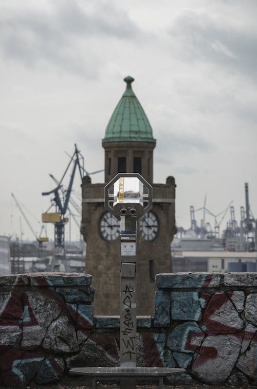 A clock on a building with graffiti on it