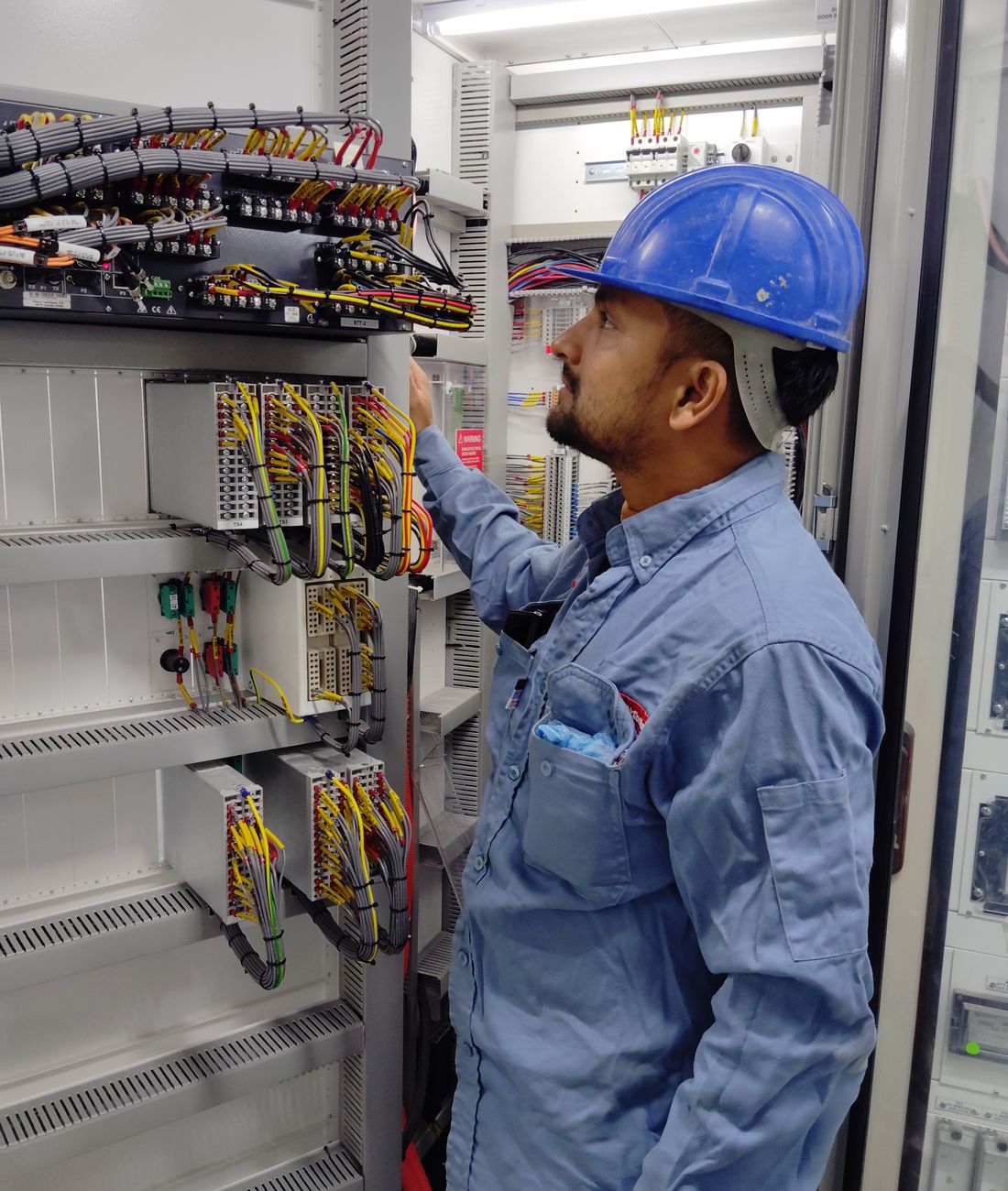 Técnico industrial trabajando en un tablero eléctrico con equipo de seguridad