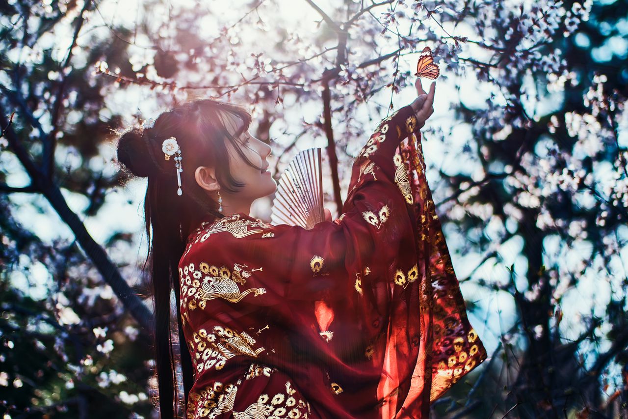 a woman in traditional chinese attire interacts gracefully with a butt
