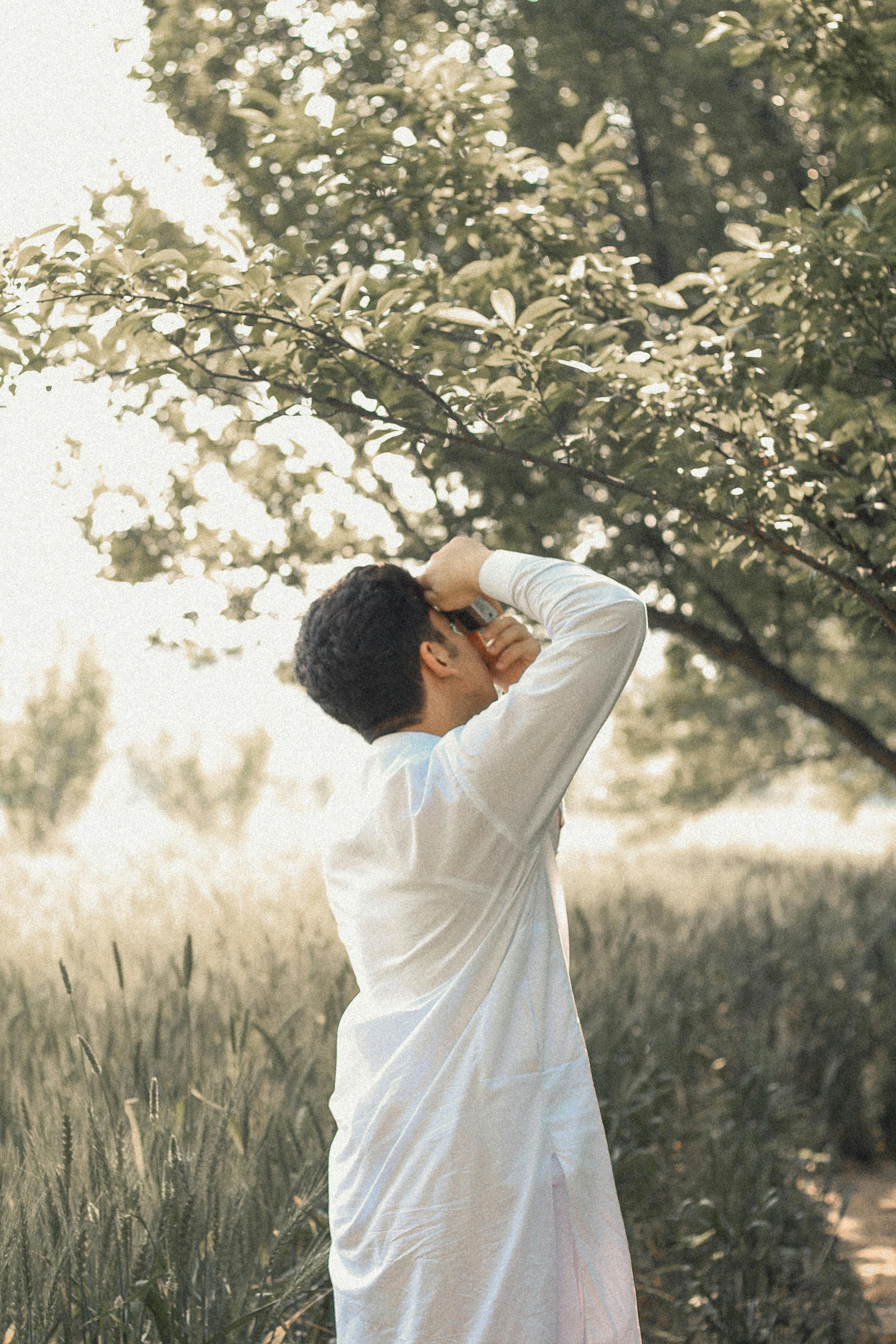 man taking photos of tree branches