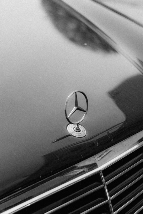 Free Elegant black and white photo focusing on a car emblem on a vehicle's hood. Stock Photo