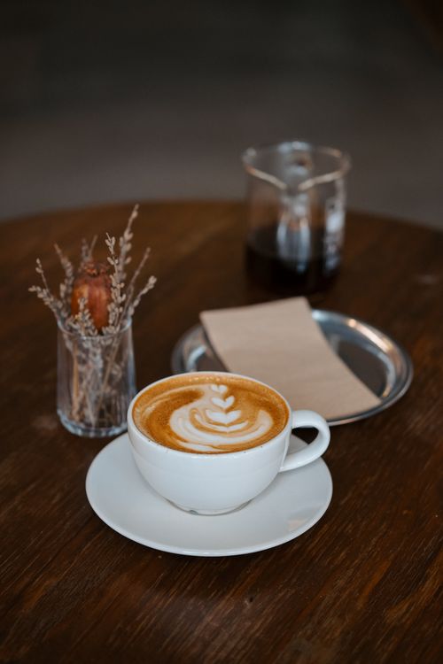 Free A cup of cappuccino with frothy latte art on a wooden table in a stylish Istanbul café. Stock Photo