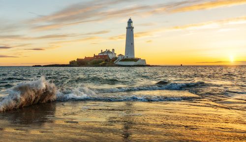 Free Beautiful sunrise at St Mary's Lighthouse, Whitley Bay, UK, with a stunning seascape view. Stock Photo