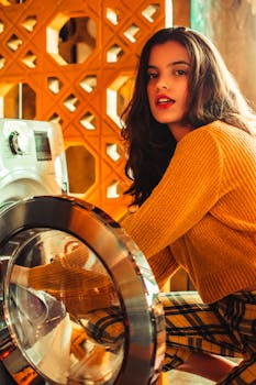 A fashionable woman in a vibrant laundromat setting, posing by a washing machine.