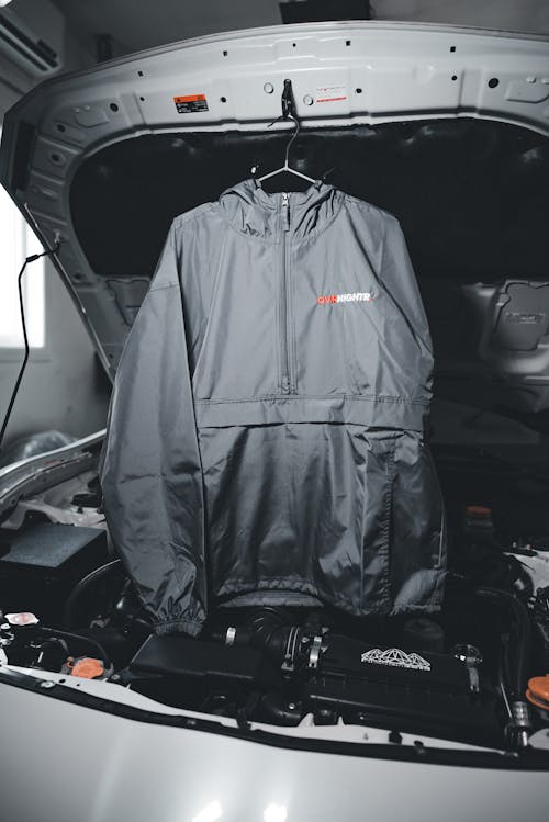 A jacket hanging from the hood of a car