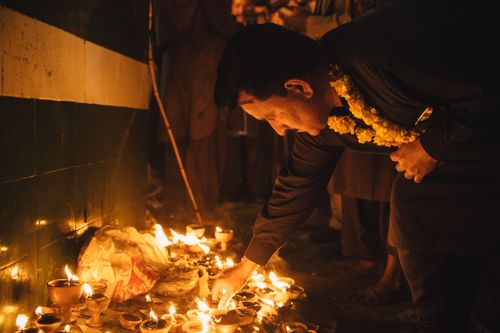 Free A man in Lahore lights candles during a traditional evening ceremony, creating a warm and serene ambiance. Stock Photo