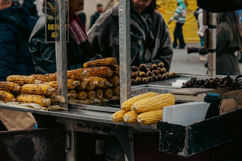 A man selling corn on a street corner