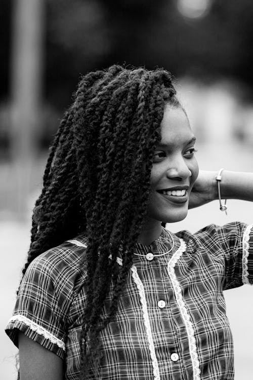 A woman with long dreadlocks is smiling for the camera