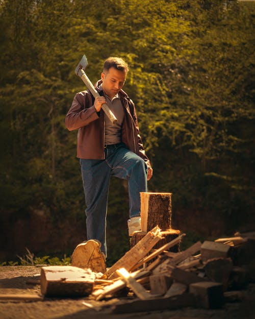 A man is standing in front of a pile of wood