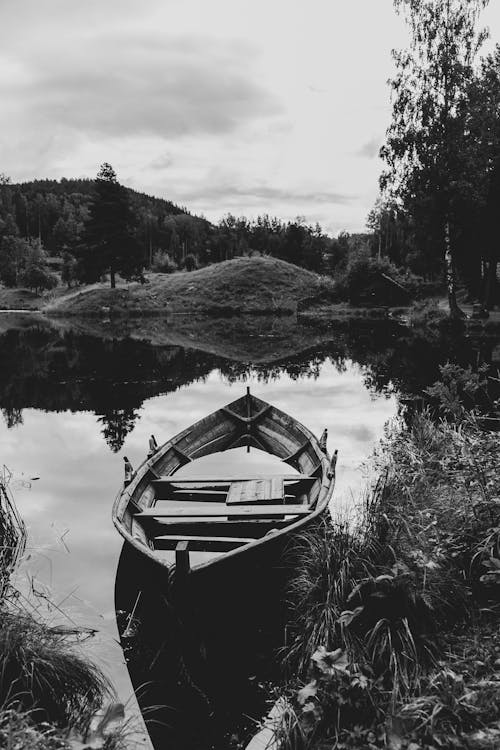 A black and white photo of a boat on a lake