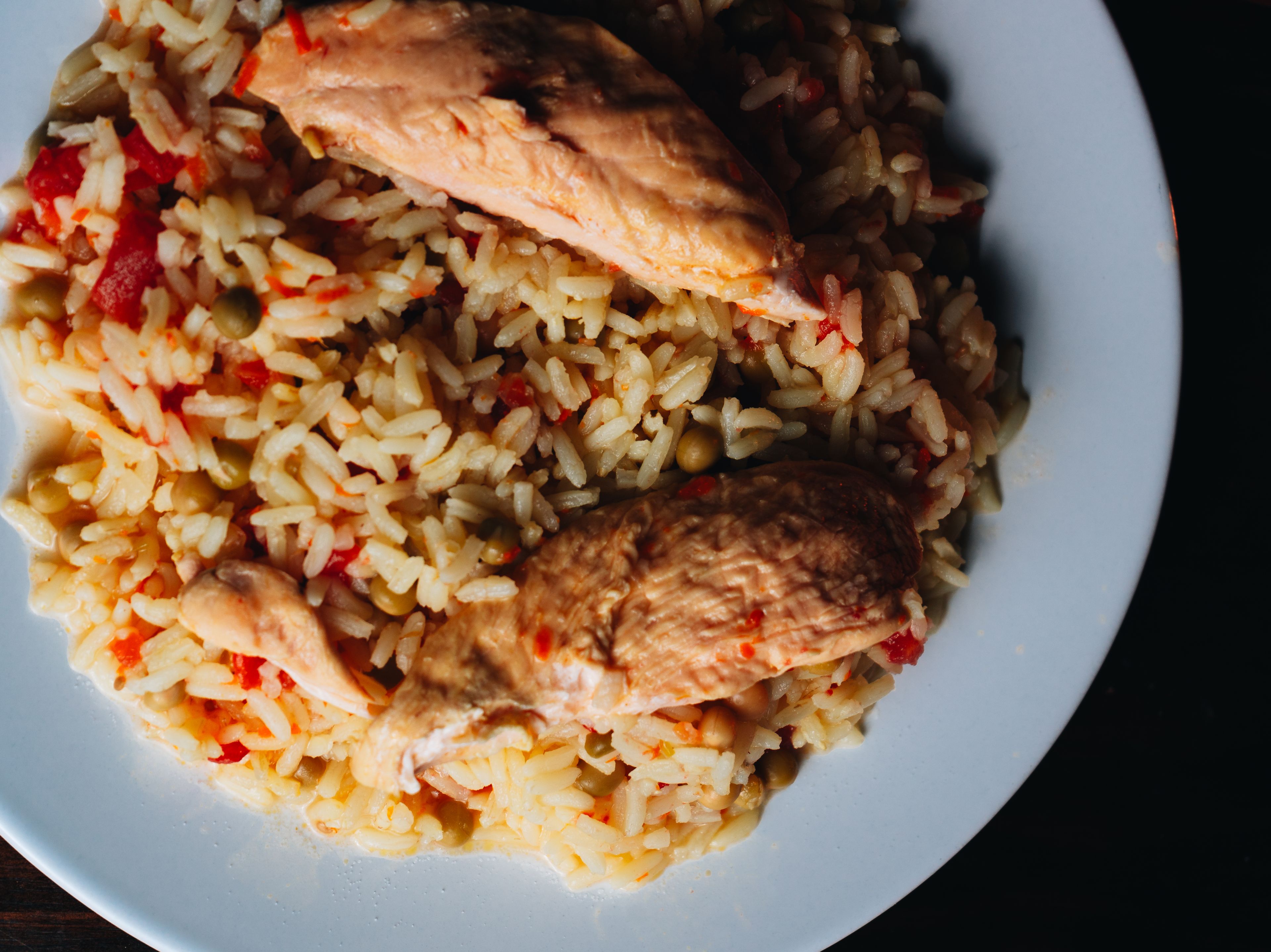 Appetizing chicken and rice dish served on a white plate, captured from above.