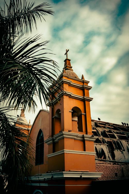 Free Vintage shot of a Catholic church tower with palm tree in Barranco, Lima, Perú. Stock Photo